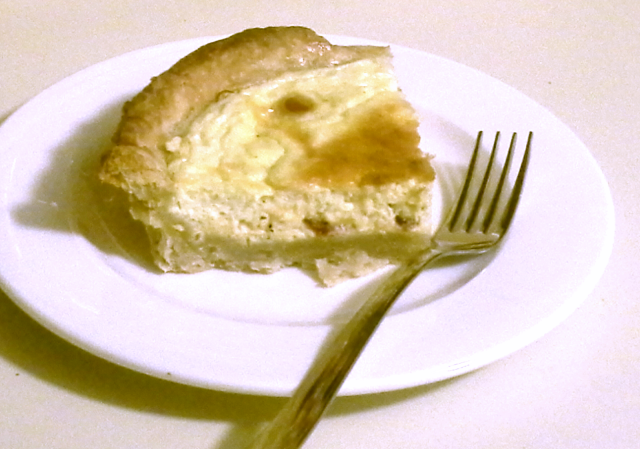 A slice of quiche on a plate with fork.